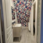Salle de bain mansardée avec papier peint floral et sol stratifié - Peinture S.L